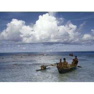  Men and Boys Paddle a Small Outrigger Canoe into a Shallow 