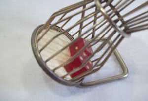 Old metal cage dice hand spinner with stand. Silver with red dice.
